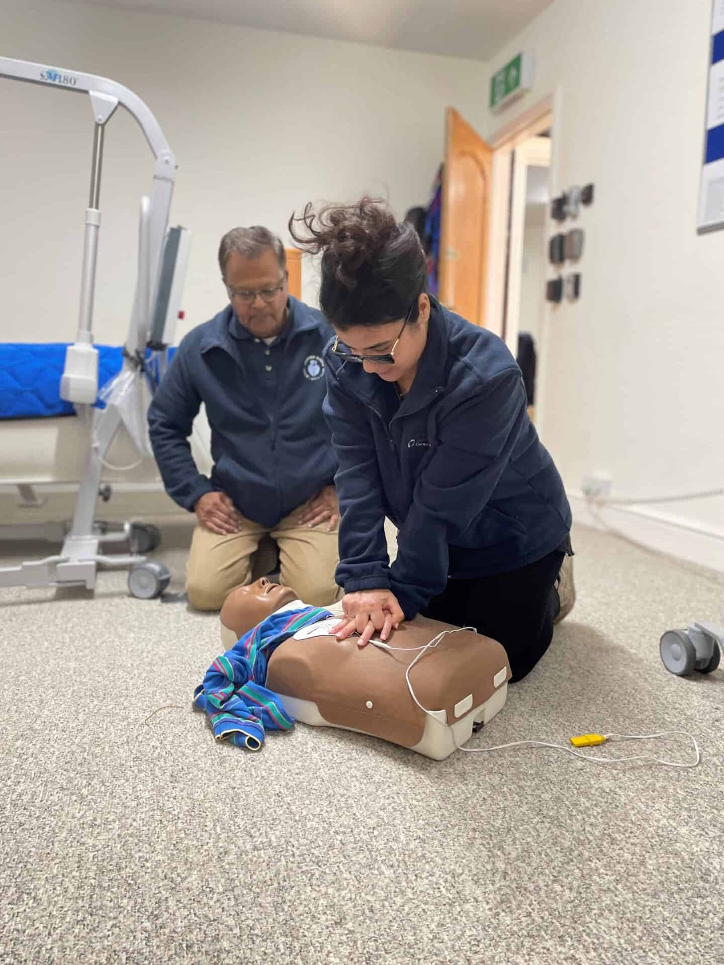 Healthcare professionals practicing cpr on a medical dummy during a training session.