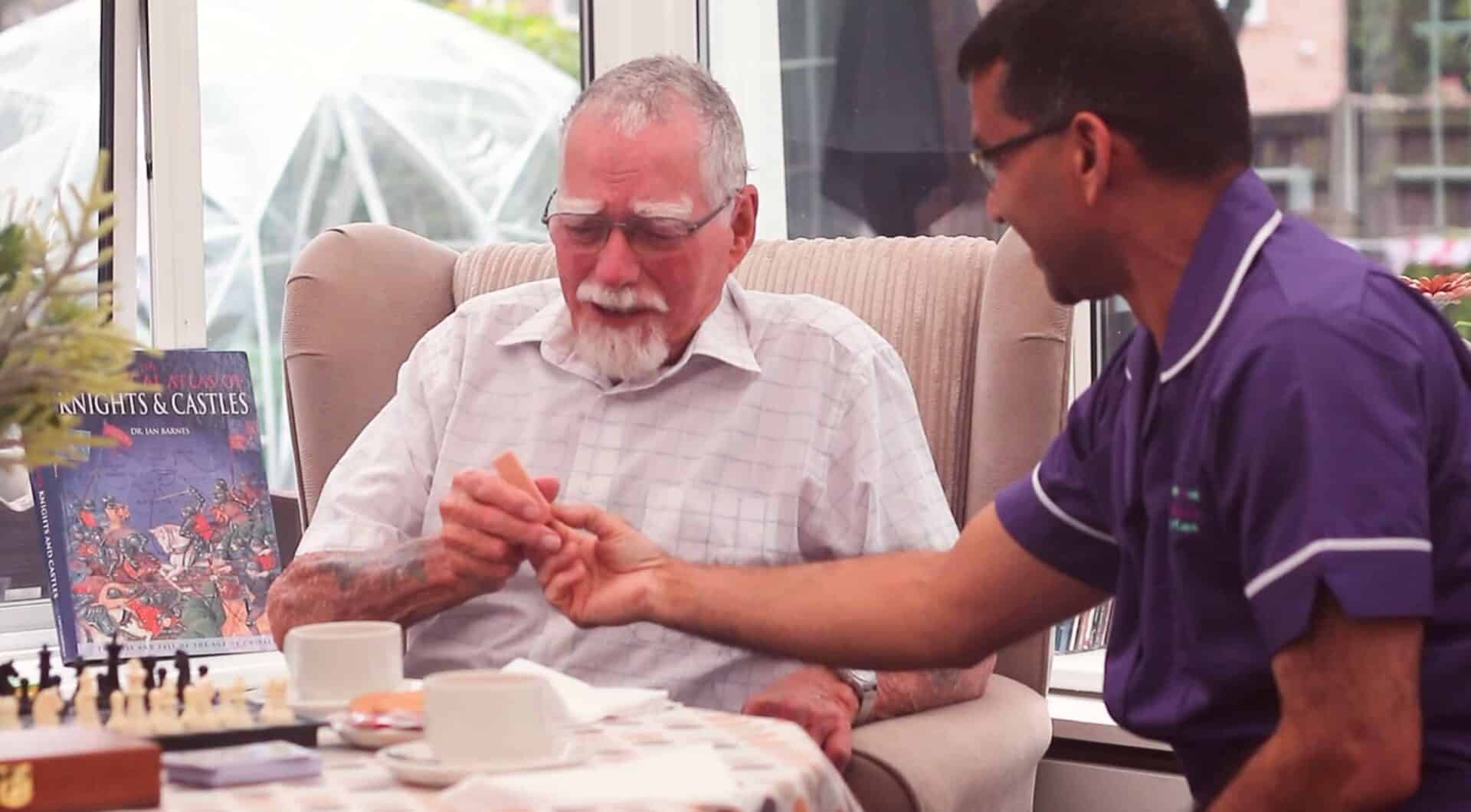 Two men share a beautiful moment of connection over a game of chess in a cozy room with a warm ambiance.